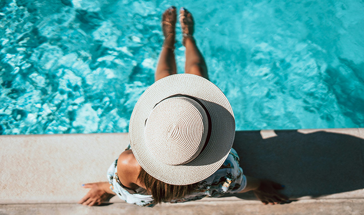 Apartment pool day with a resident relaxing by the water in a bright and inviting community pool area