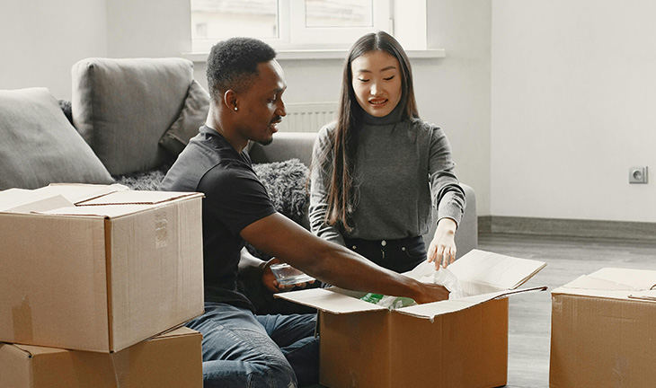 New residents unpacking and getting comfortable in a bright, modern apartment home