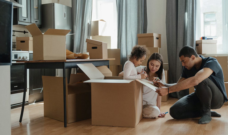Young family unpacking boxes while moving into a new apartment