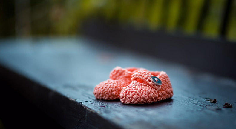 Pink knitted baby booties for a growing family in an apartment