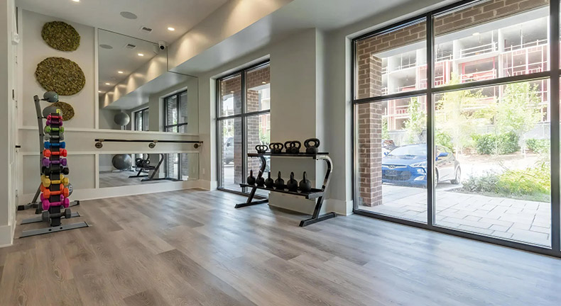 Apartment fitness center with shared workout equipment and open floor space